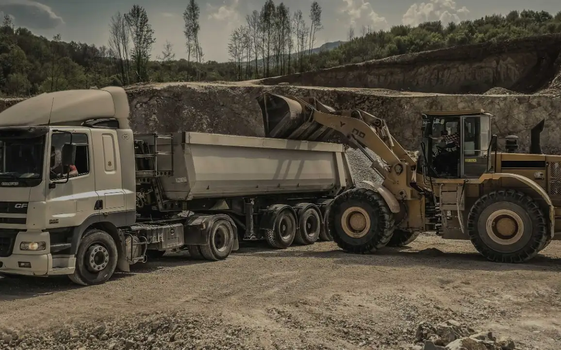 A loader filling a truck at a quarry